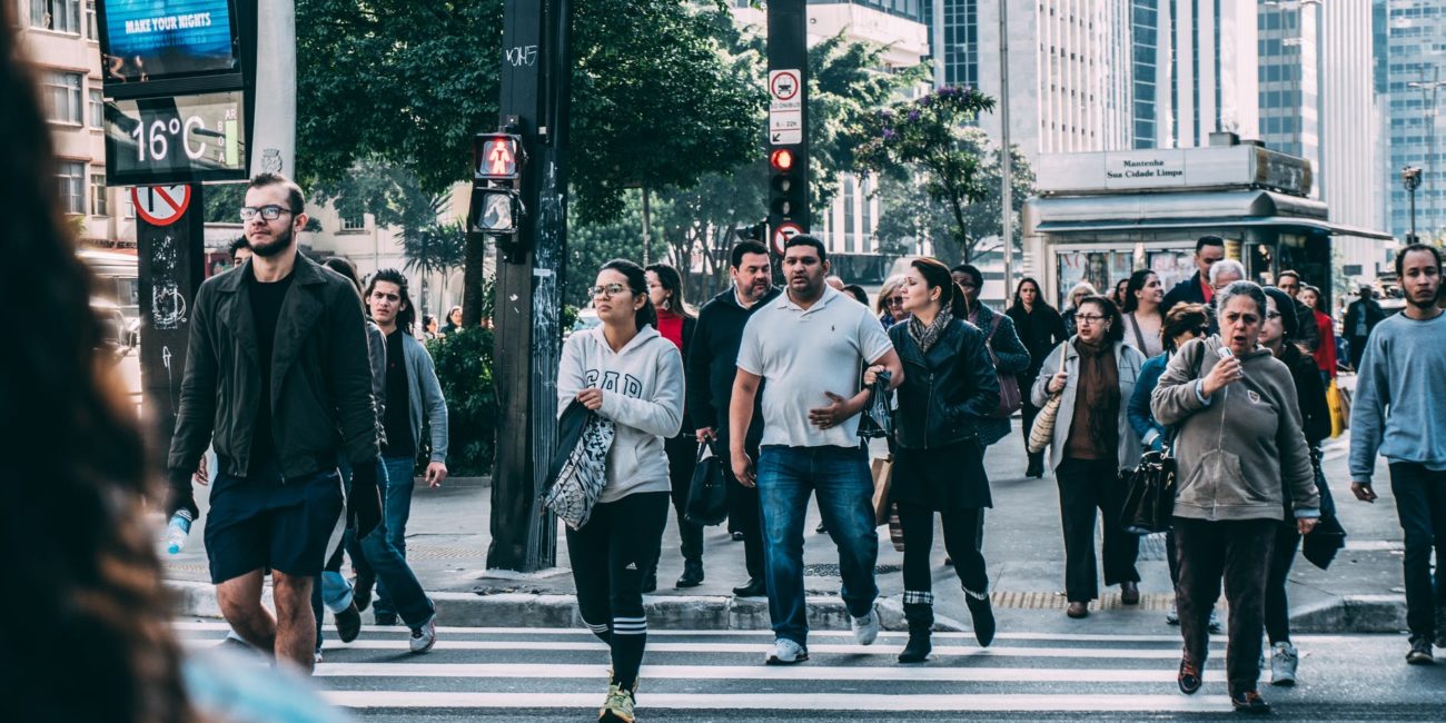 Crowd of people walking across a crosswalk