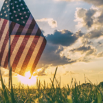 American flag in front of a sunset