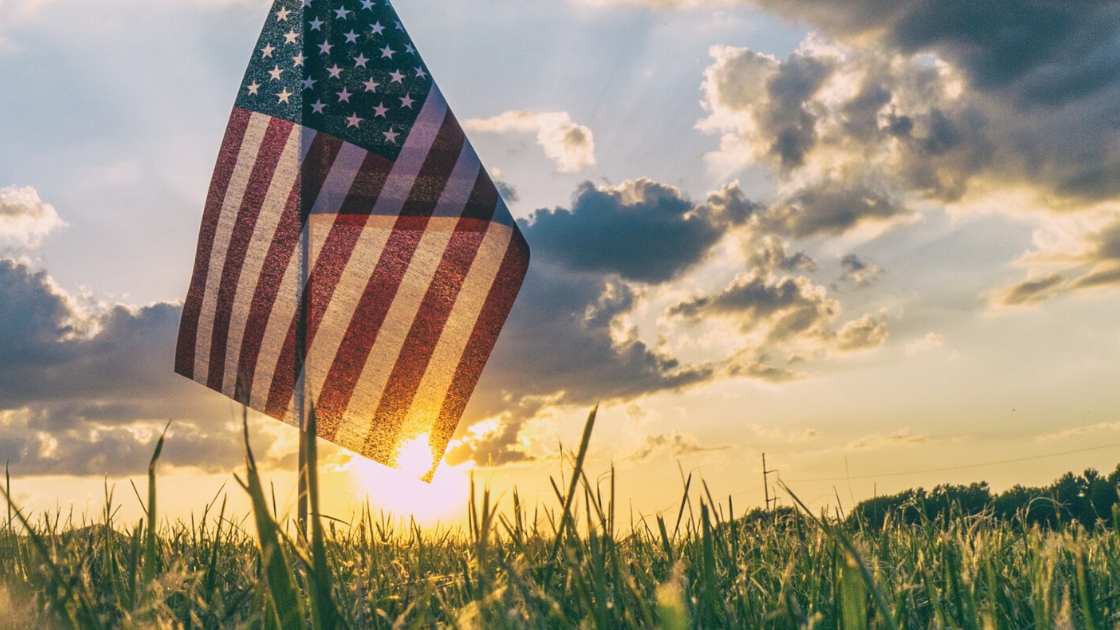 American flag in front of a sunset