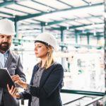 Two manufacturing professionals examining a marketing document