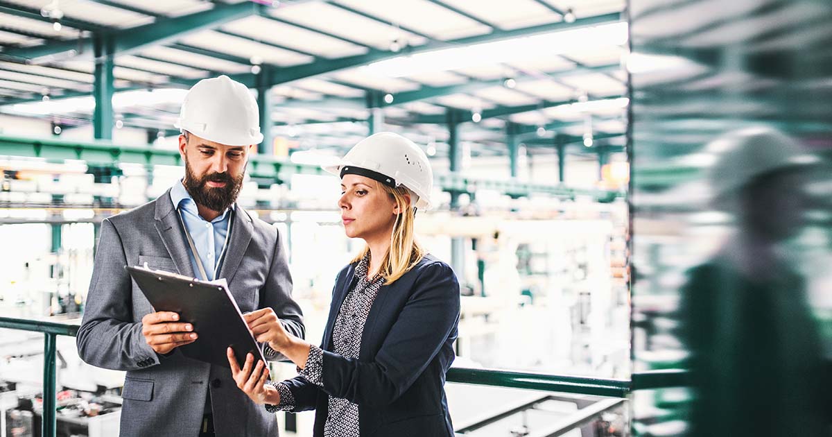 Two manufacturing professionals examining a marketing document