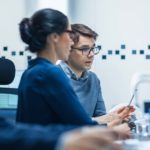 Two people sitting side-by-side analyzing their marketing plan on the computer