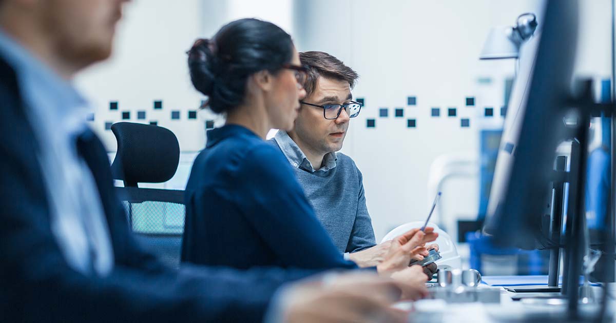 Two people sitting side-by-side analyzing their marketing plan on the computer