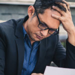 Business man looking down at a paper document