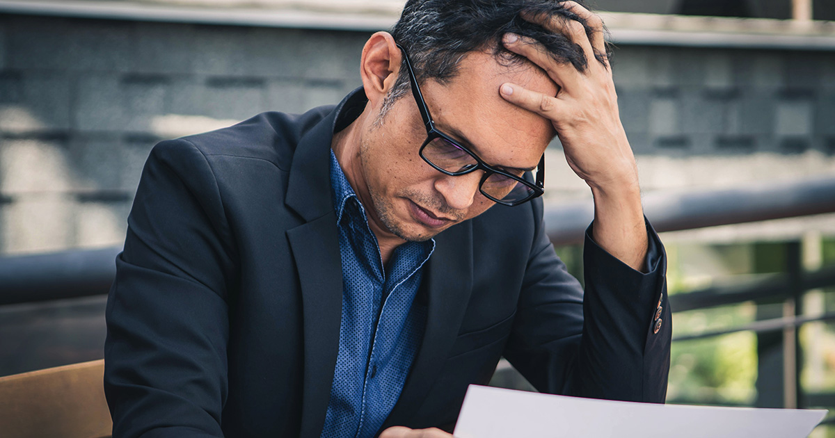 Business man looking down at a paper document